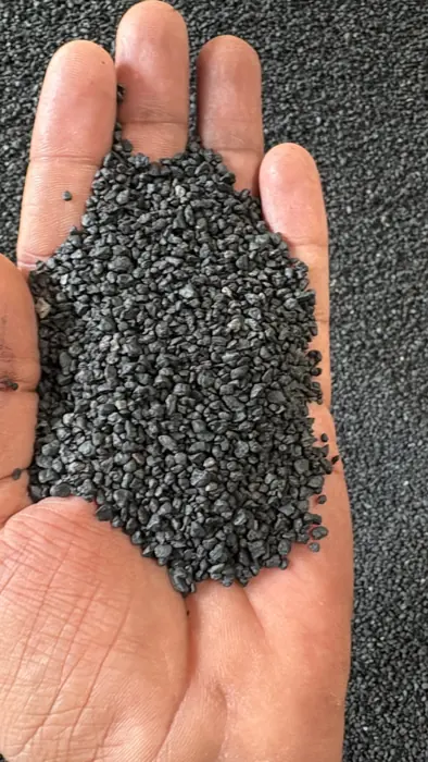 Black humic granules held in an open hand